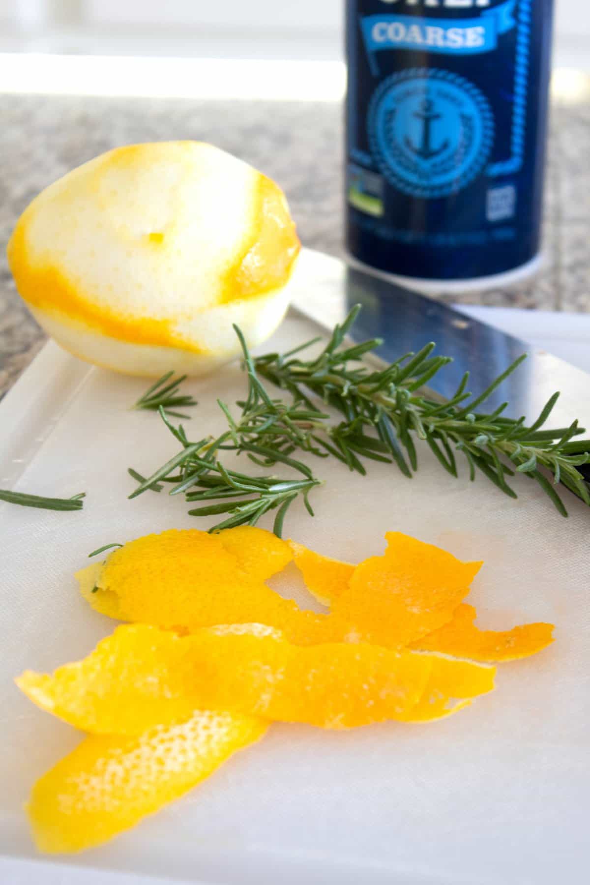 lemon peel and fresh rosemary on a cutting board