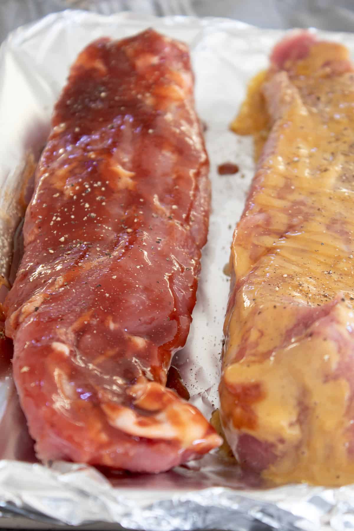 2 pork tenderloins on a sheet tray lined with foil