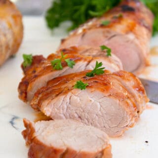 sliced baked pork tenderloin garnished with parsley