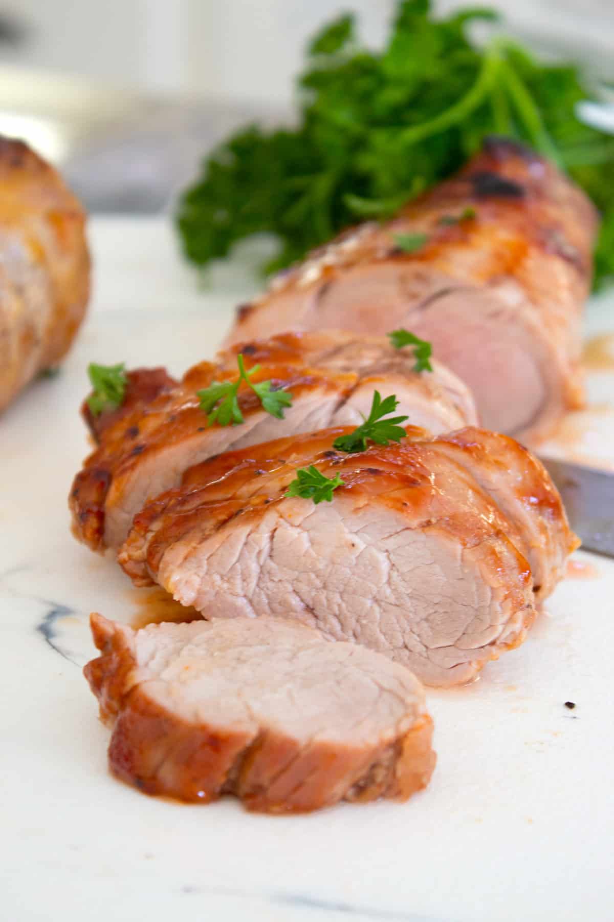 sliced baked pork tenderloin garnished with parsley