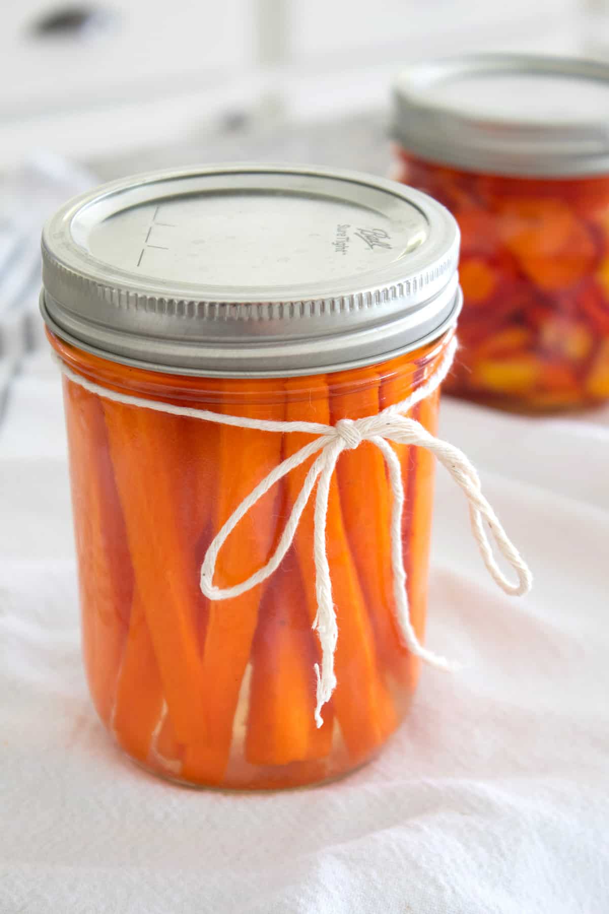 mason jar full of pickled carrots tied with twine