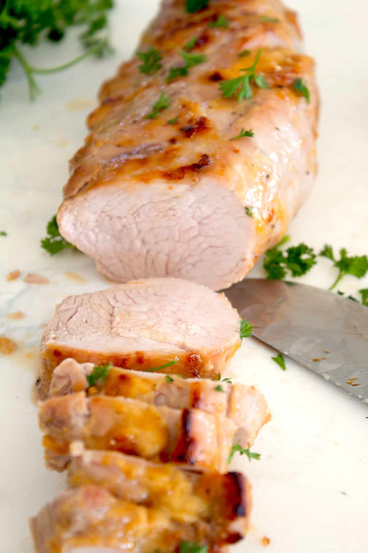 honey musard pork being sliced on a cutting board