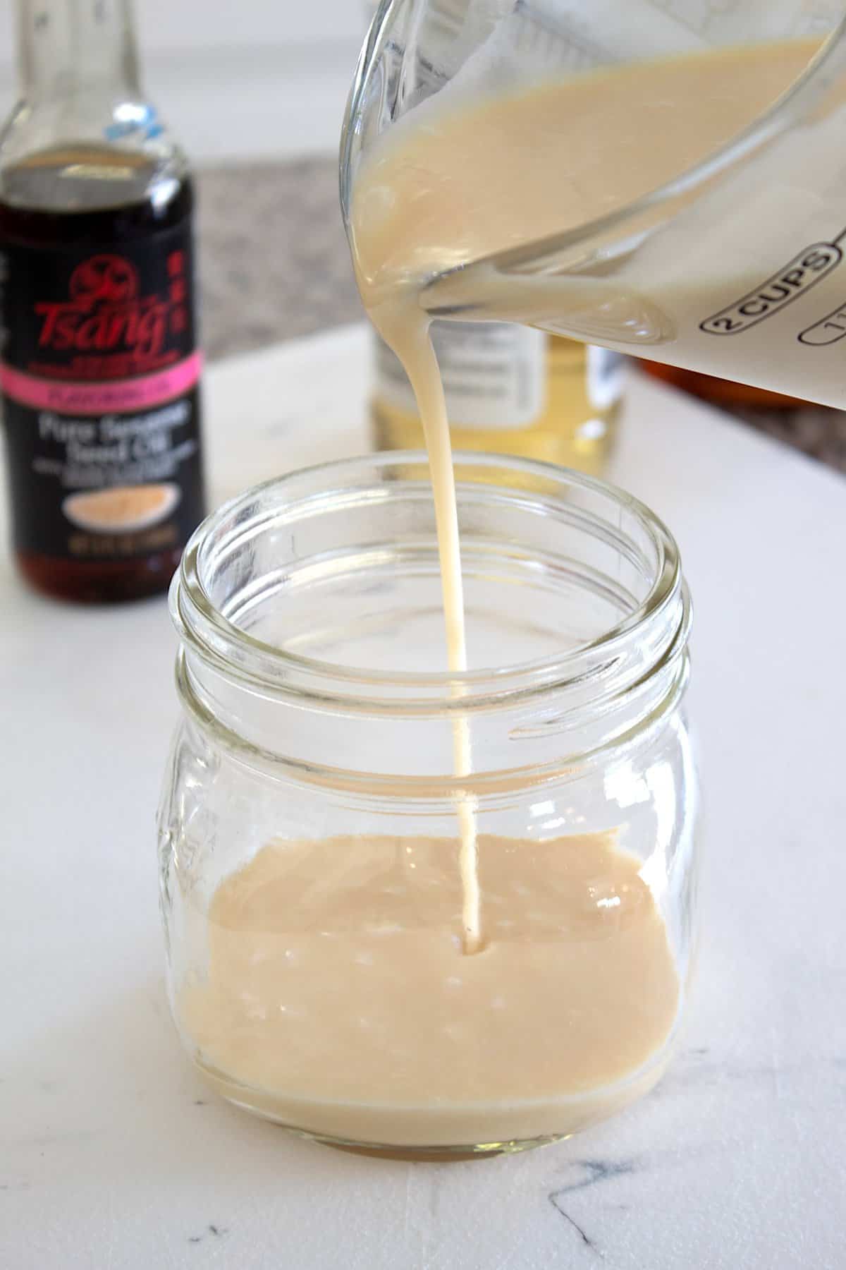 pouring dressing into a mason jar