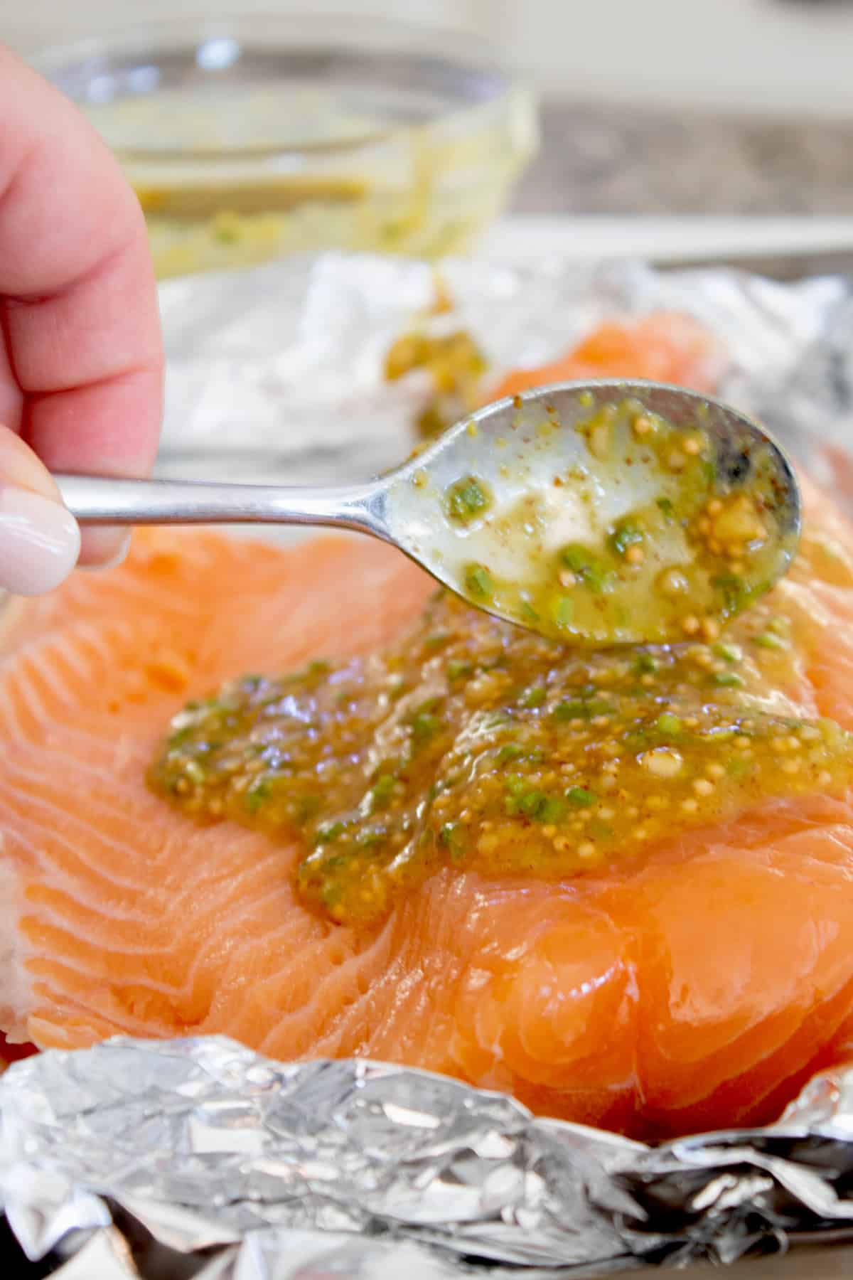 adding honey mustard glaze to salmon