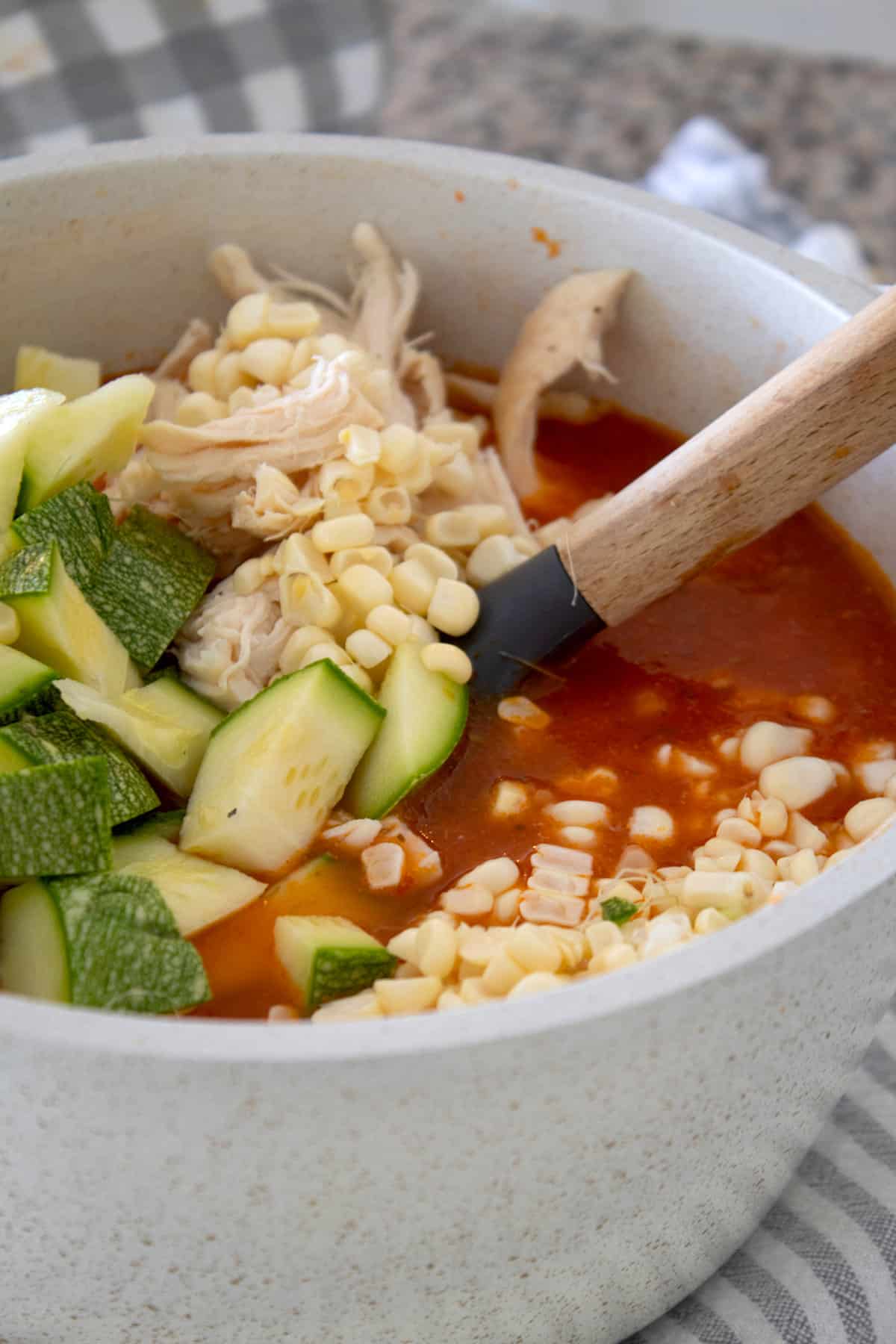 adding extra vegetables and chicken to soap de fideo