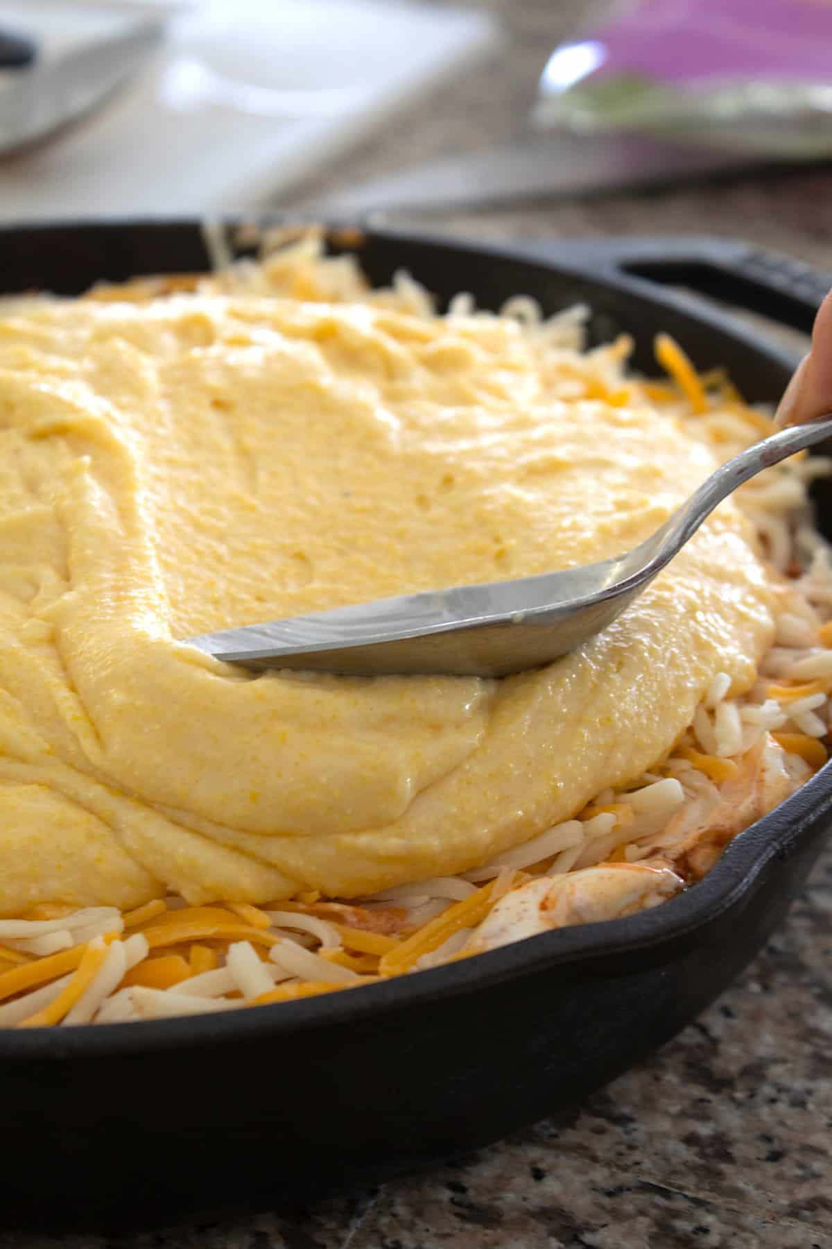 pouring batter over chili