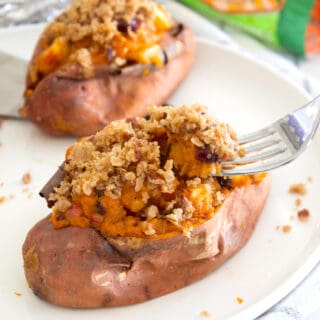 stuffed sweet potato with streusel topping on a plate with a fork