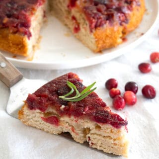 slice of cranberry upside down cake garnished with rosemary
