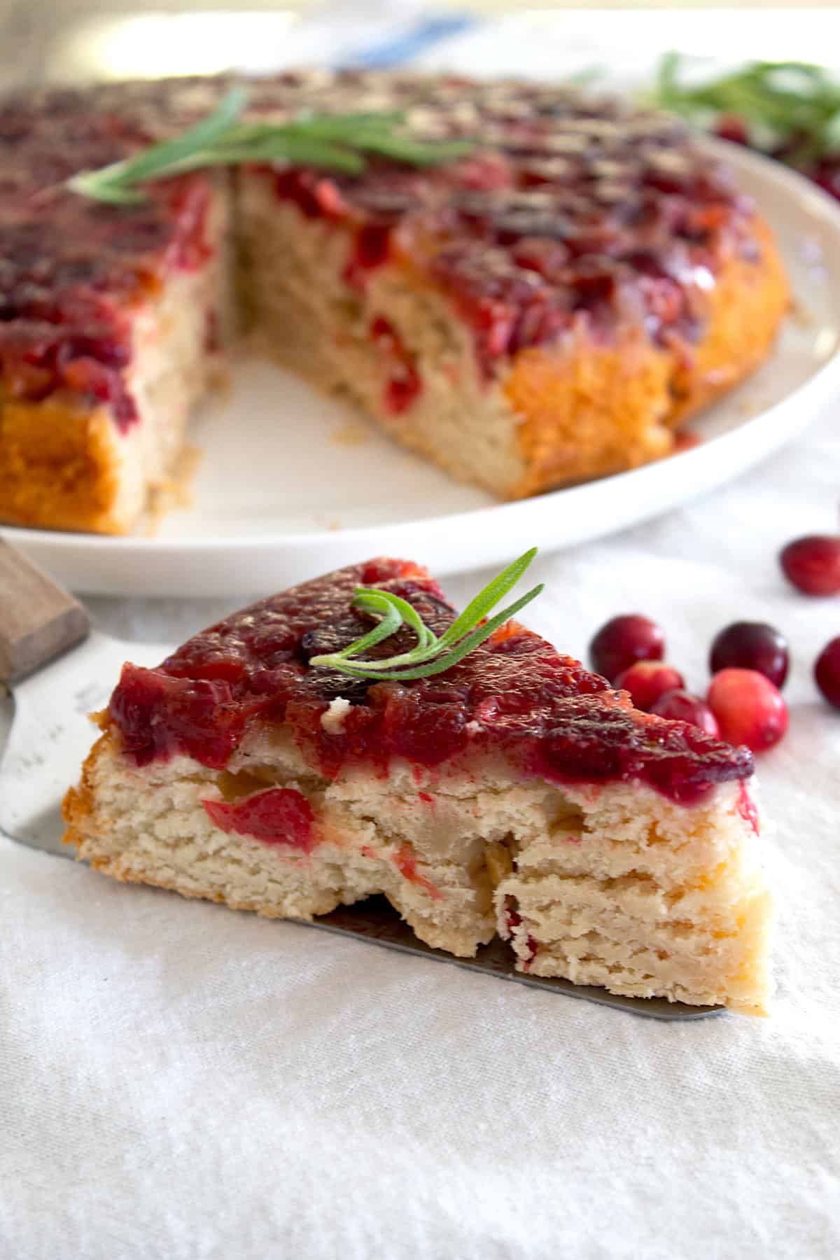 cranberry upside down cake on a serving platter sliced