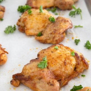 chicken thighs on sheet pan with parsley garnish