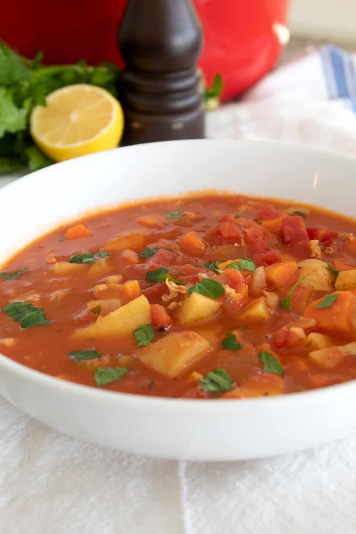 bowl of Manhattan clam chowder with lemon in background