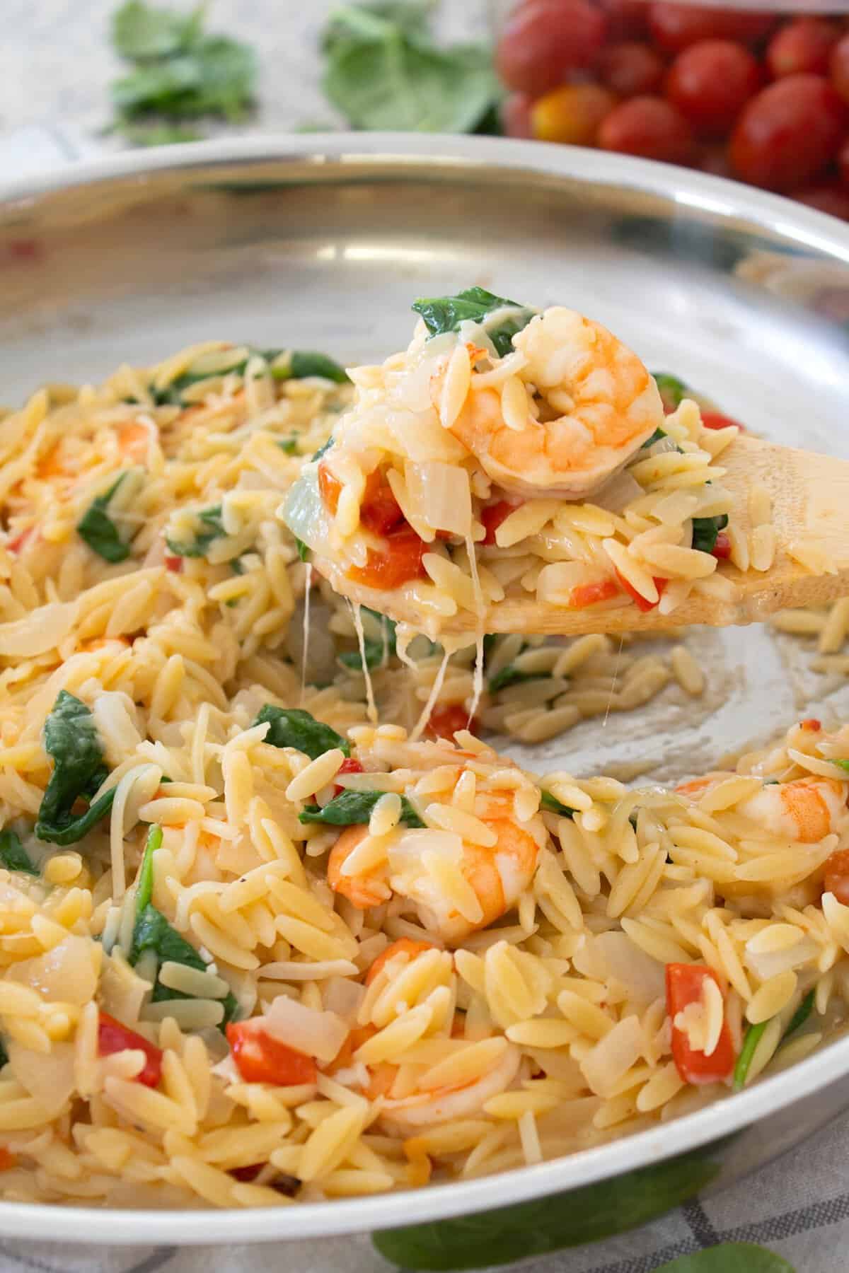 tuscan shrimp orzo dinner on a wooden spatula