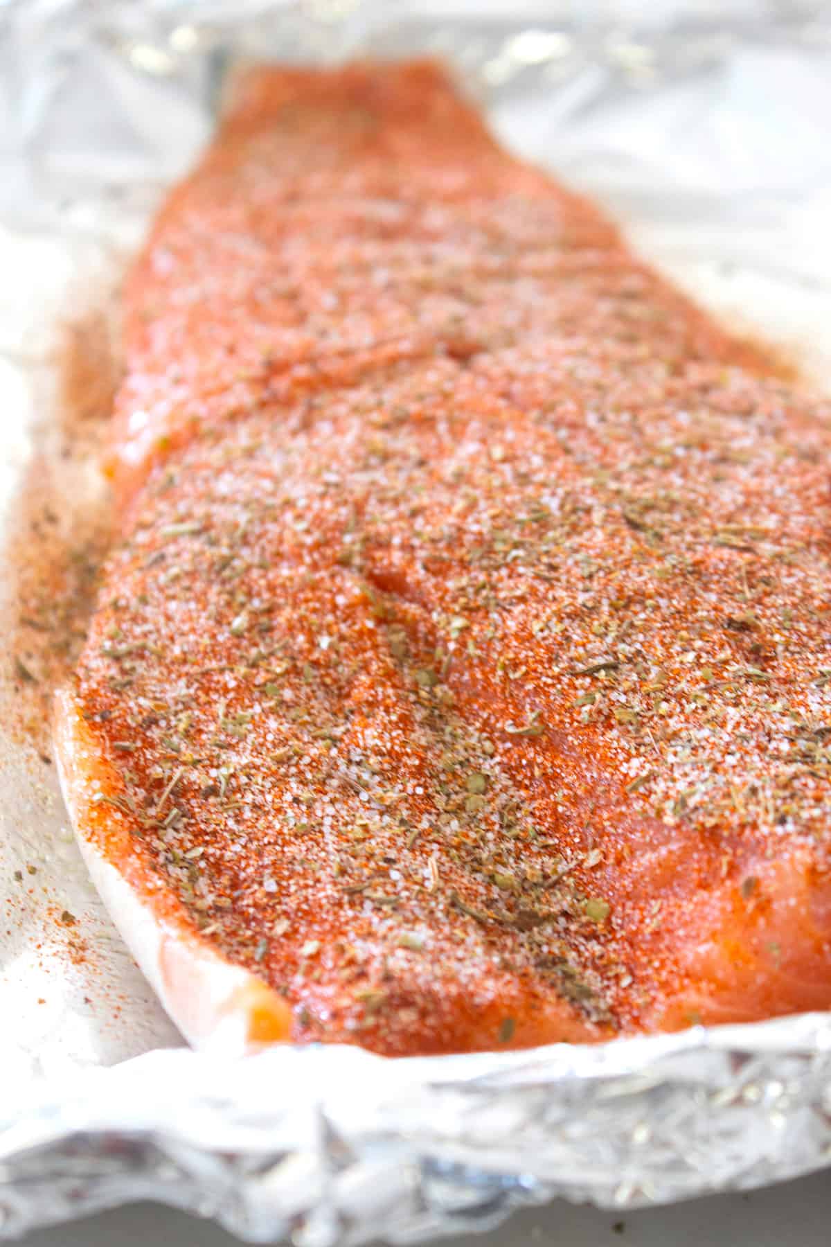 filet of seasoned salmon on foil lined platter