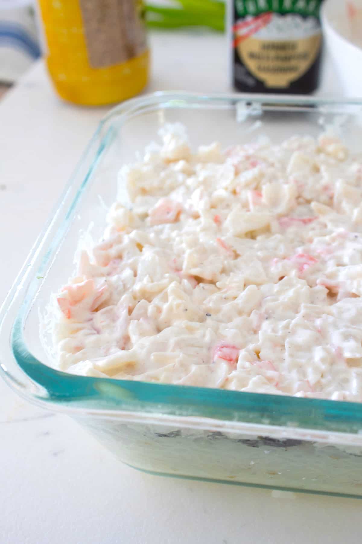 adding crab mixture over sushi bake casserole