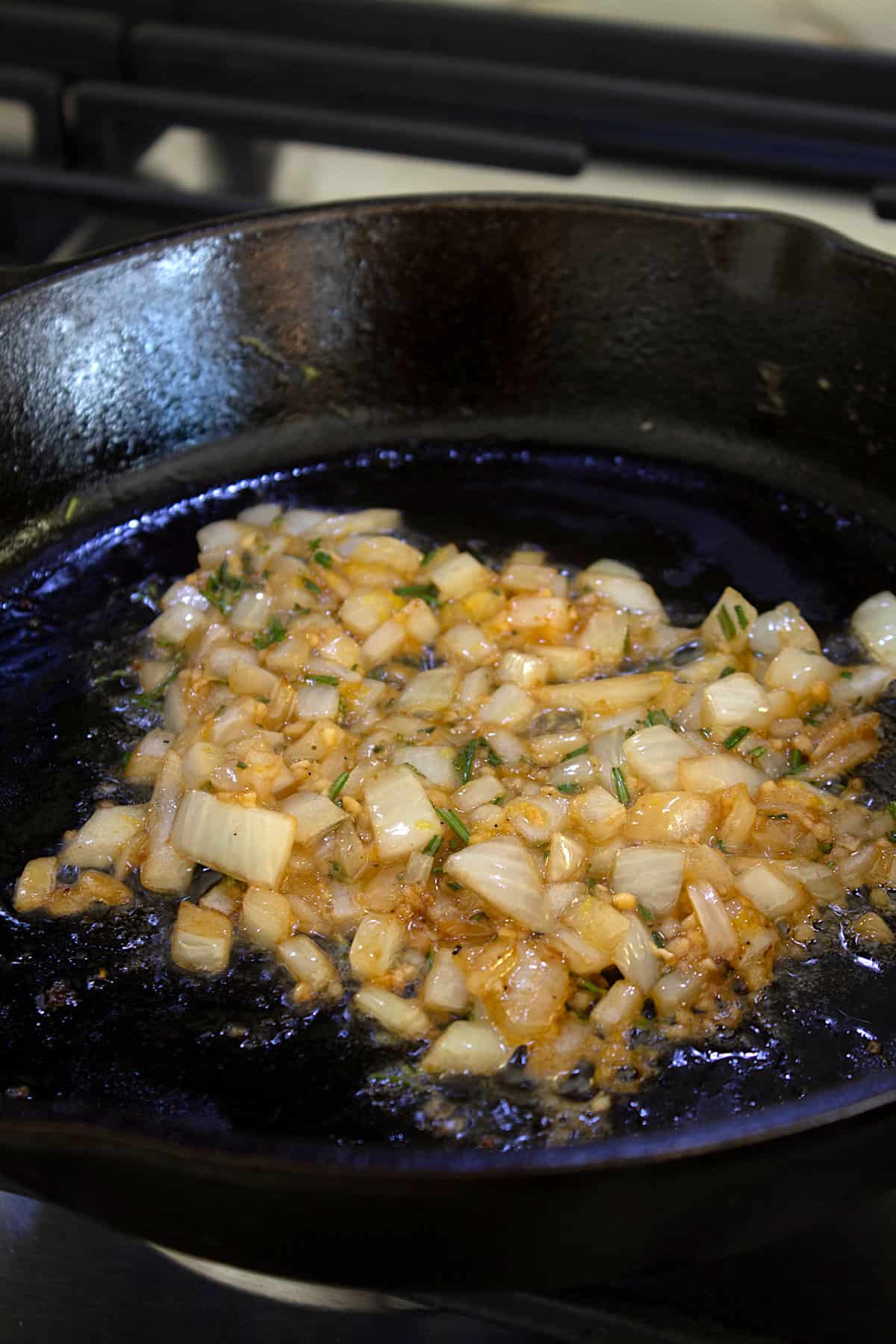 sautéed onions and rosemary in a cast iron pan