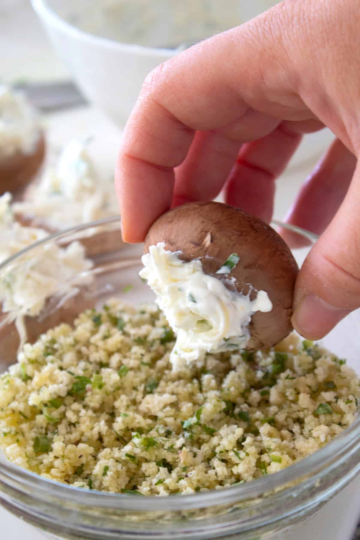 pressing stuffed mushroom into panko crumb mixture