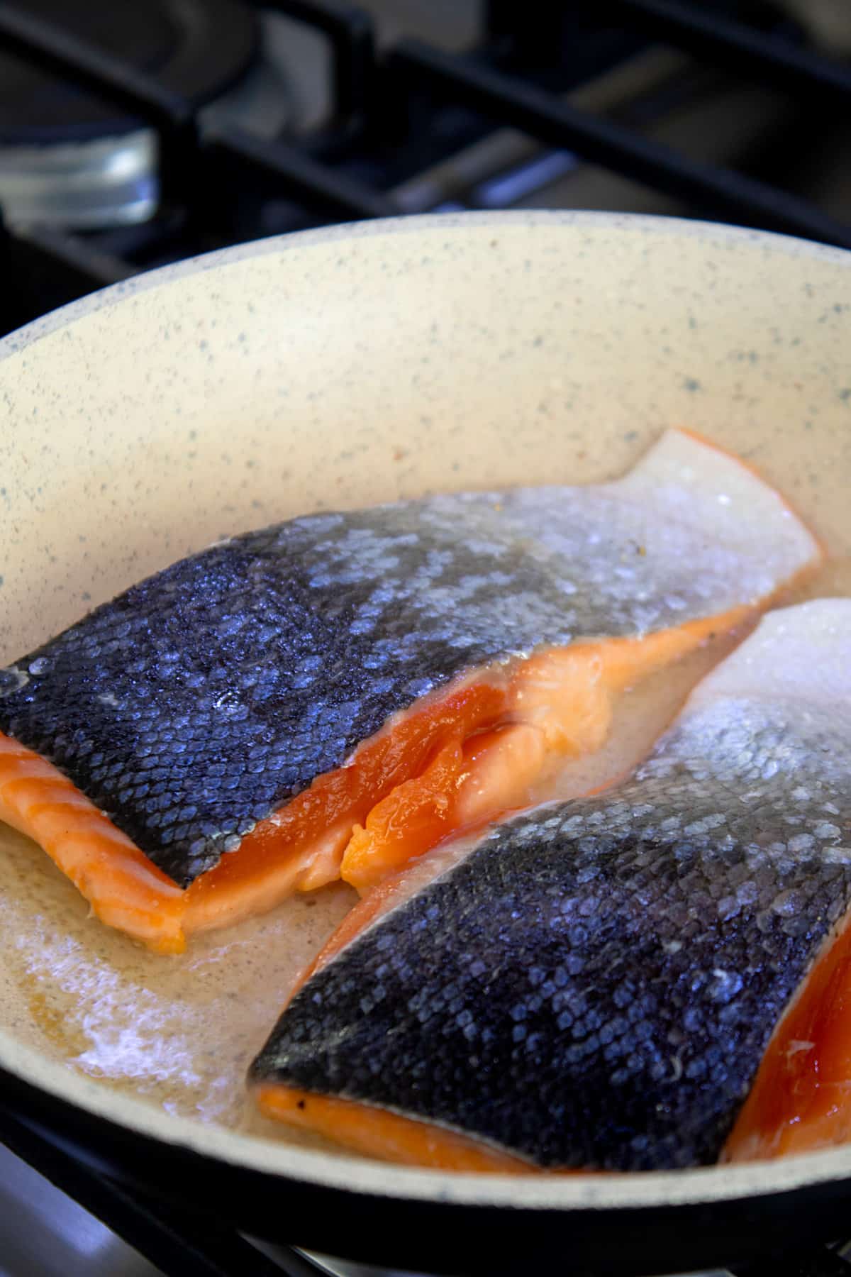flesh side down salmon searing in pan