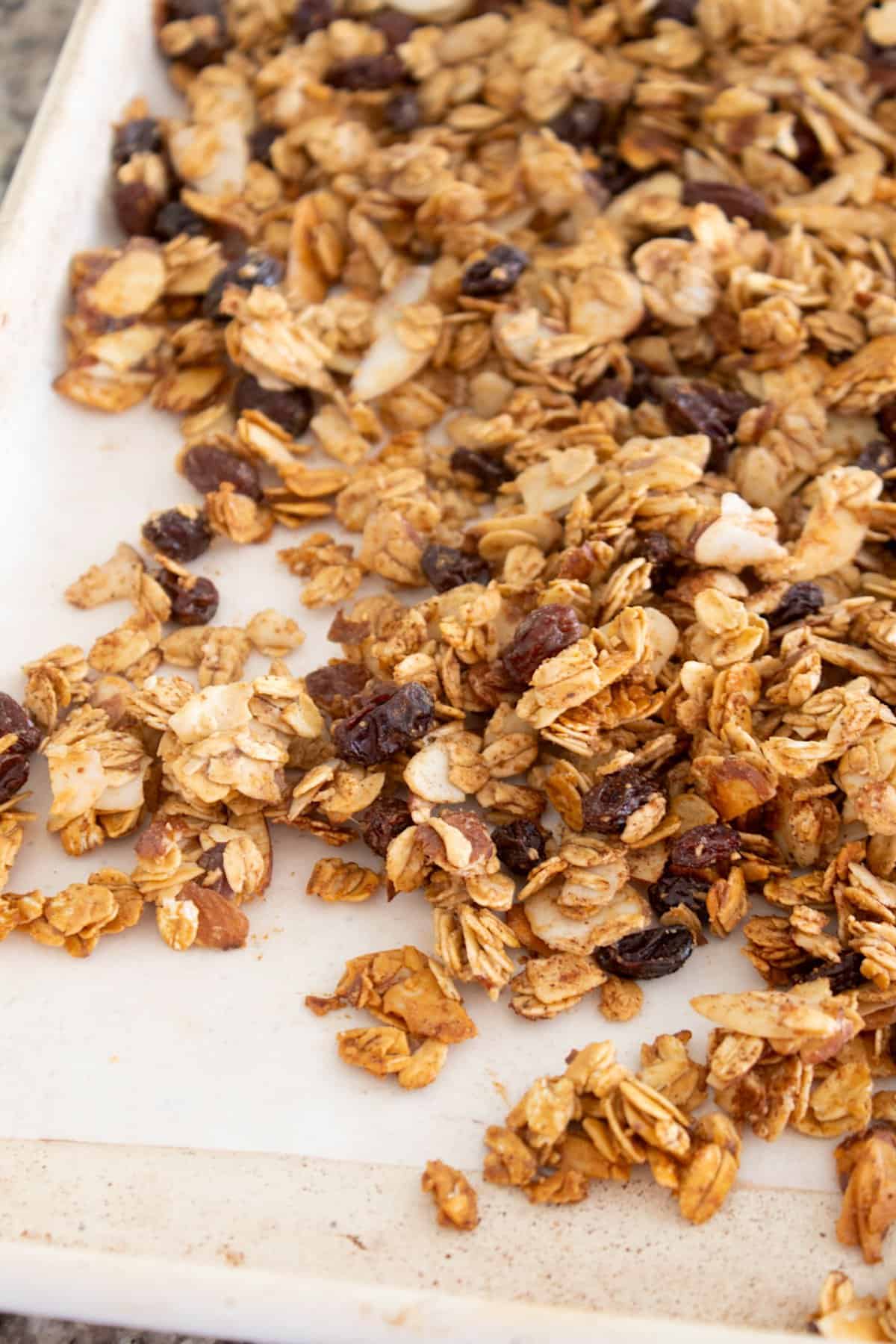 cooked granola on parchment paper on a white sheet pan