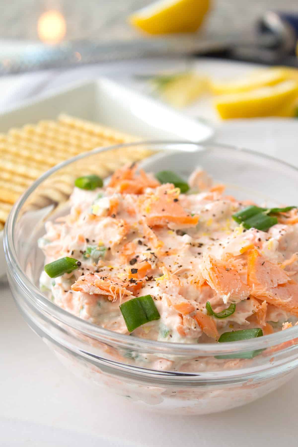 smoked salmon dip in a clear bowl with green onion garnish