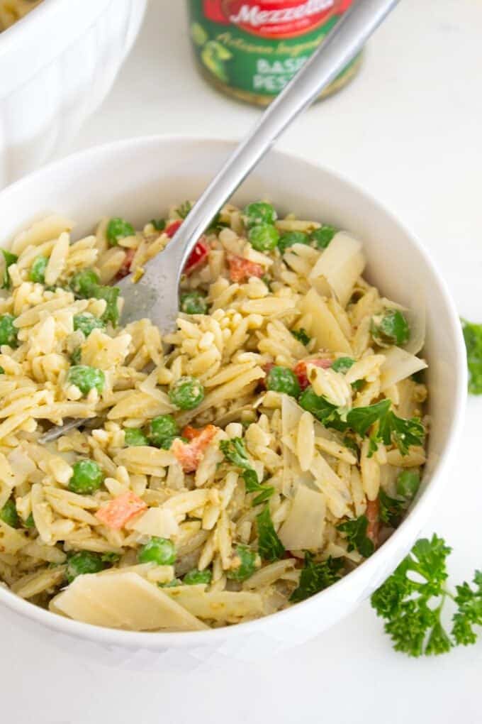 pesto orzo salad in a white bowl