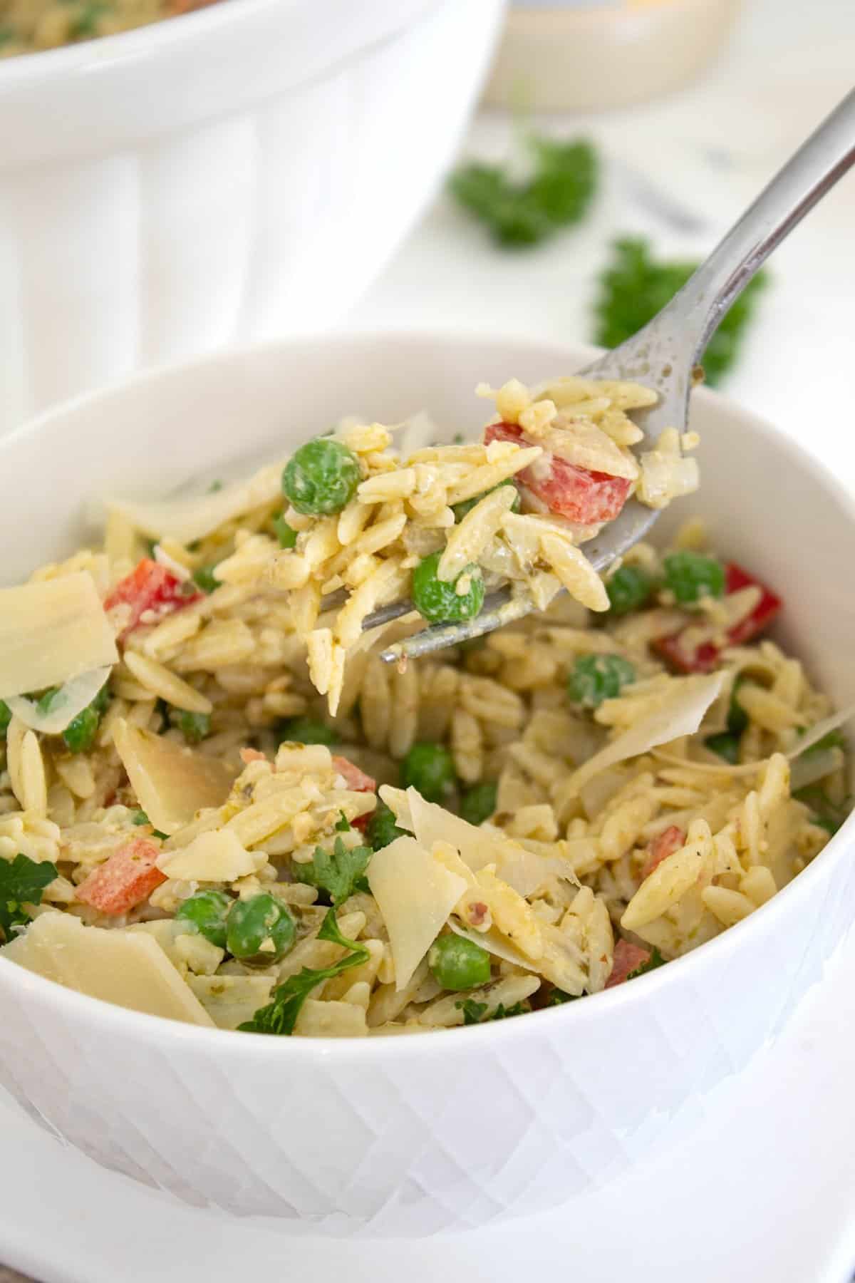 pesto orzo salad in a bowl on a fork