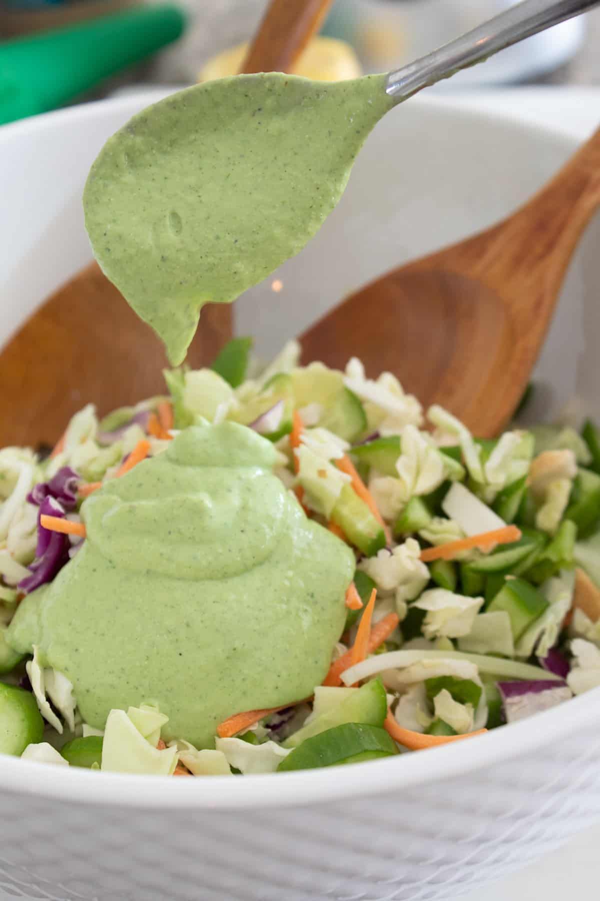 Green goddess dressing being poured on salad