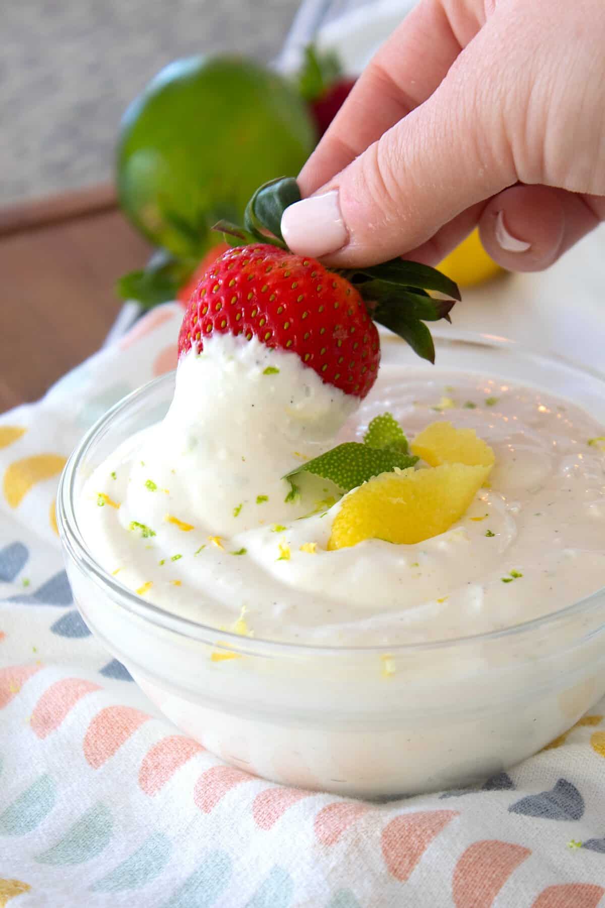 Dipping a strawberry in white fruit dip