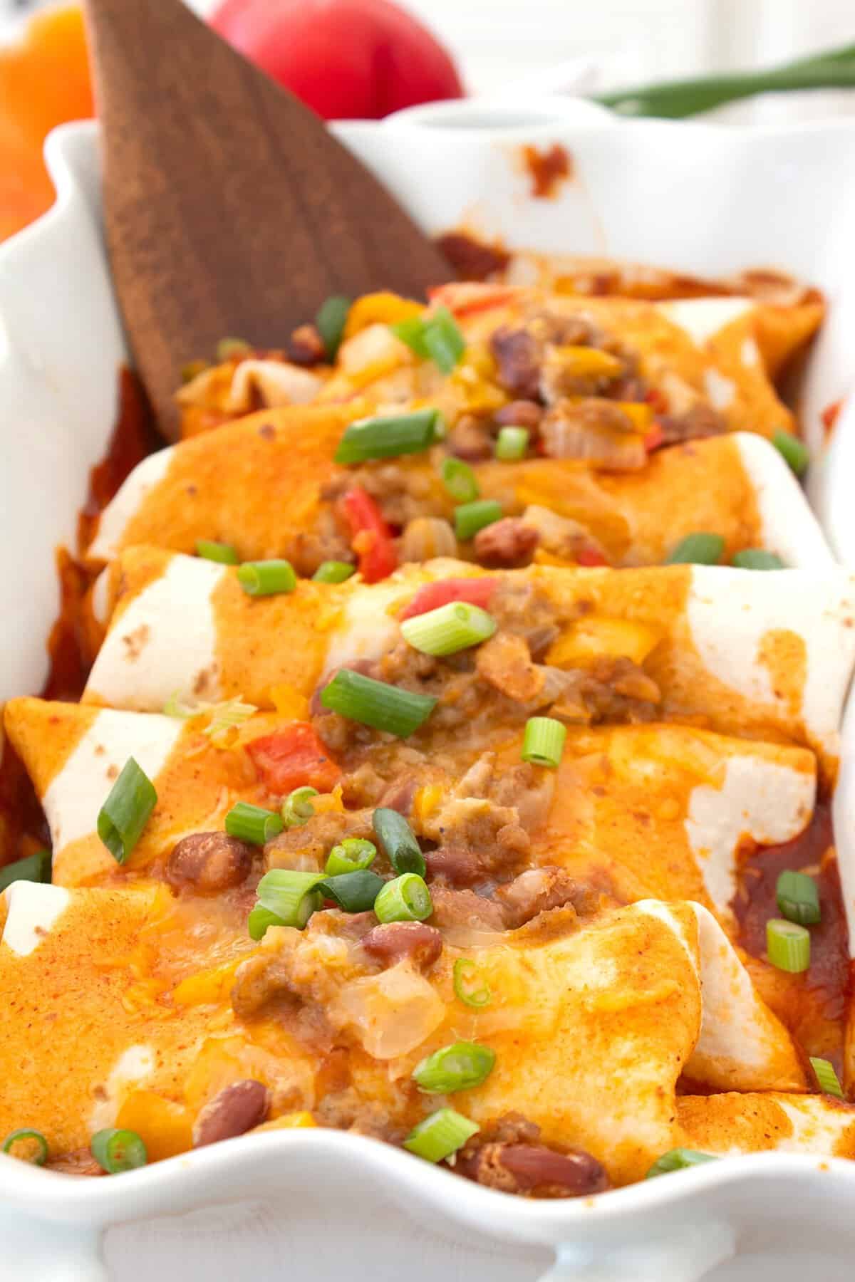 ground turkey enchiladas in a white casserole pan