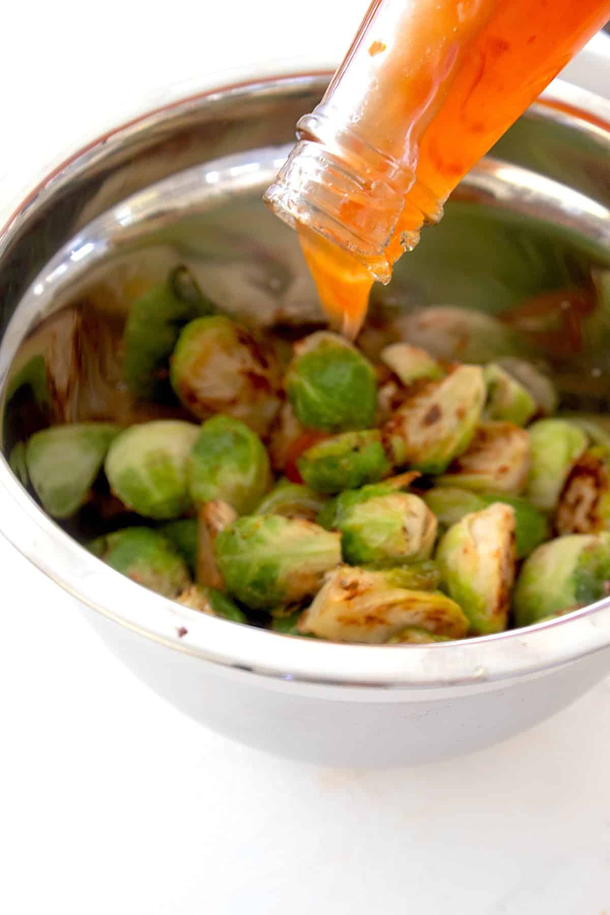 brussel sprouts in a bowl with chili sauce