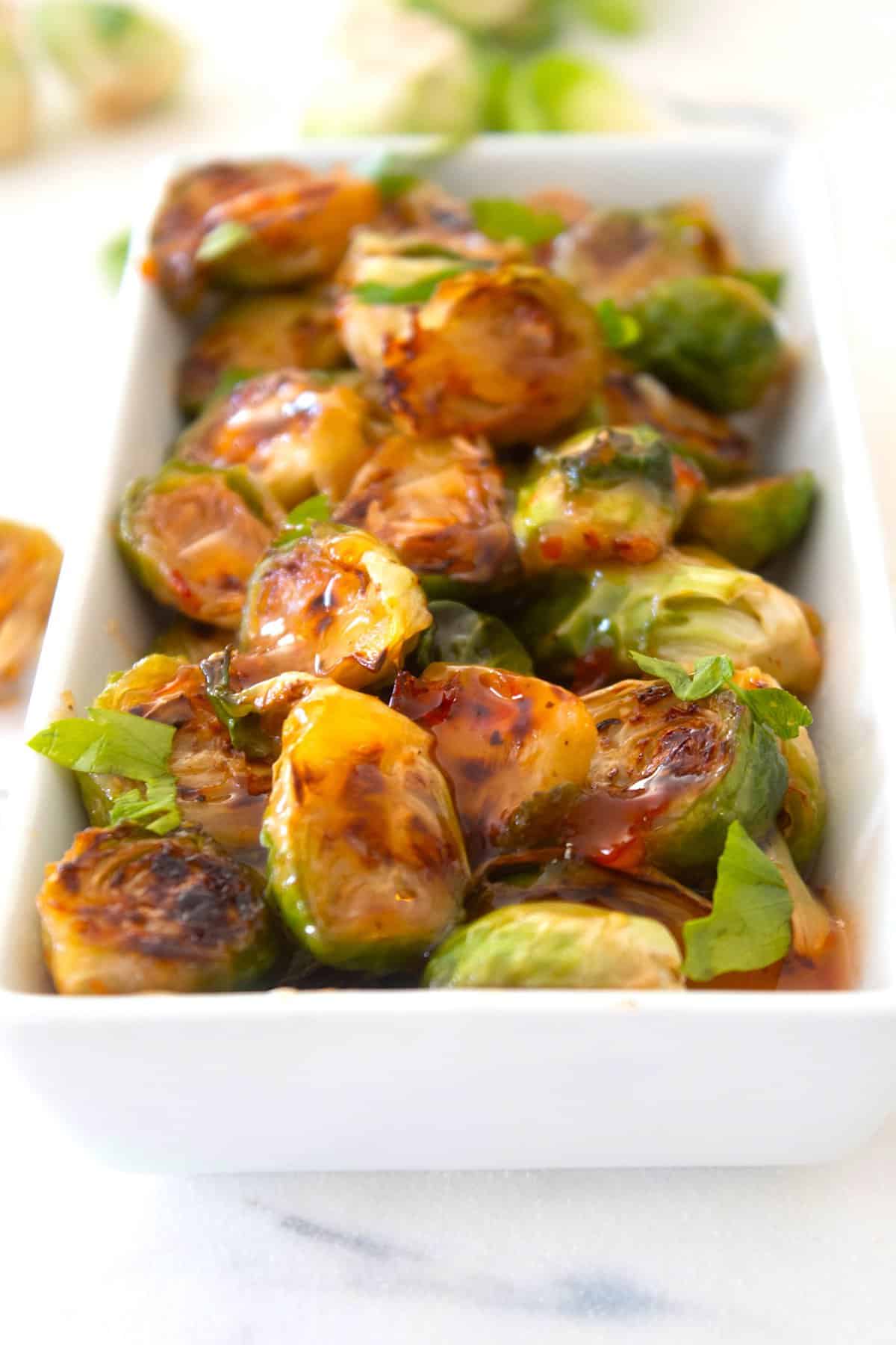 thai chili brussel sprouts in a white dish