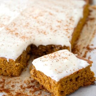 pumpkin snack cake on parchment paper with piece cut out