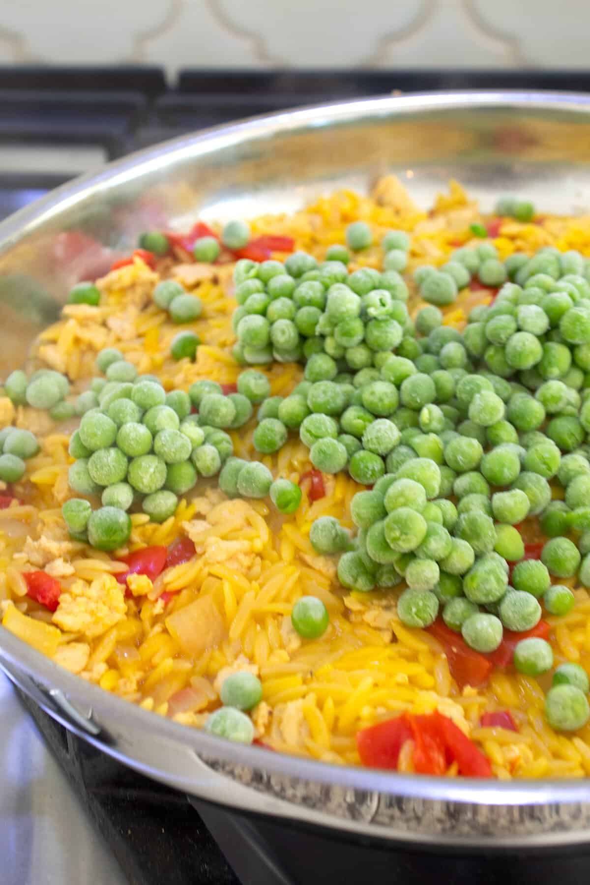 adding frozen peas to skillet