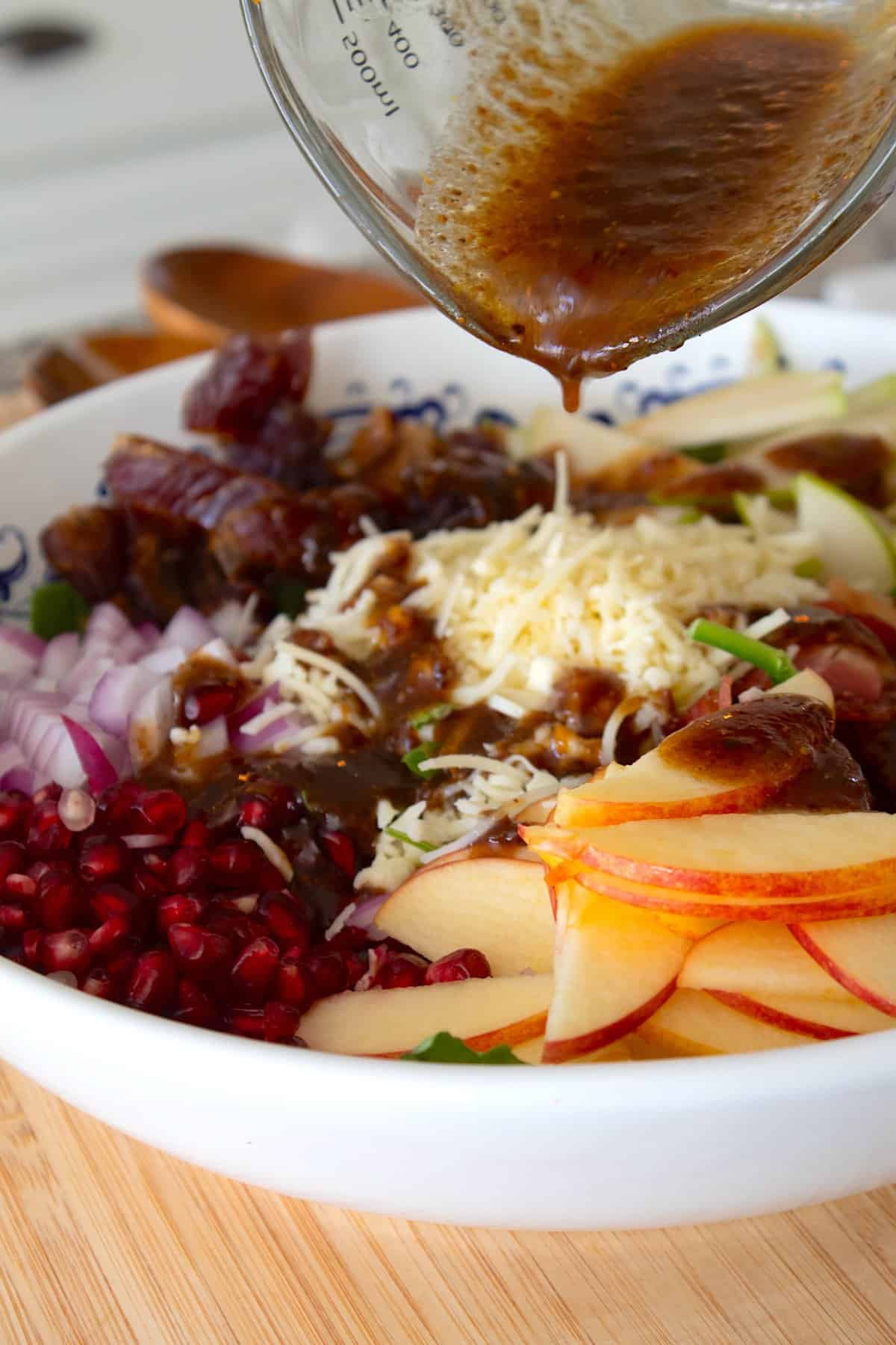 dressing Christmas Salad in a white bowl