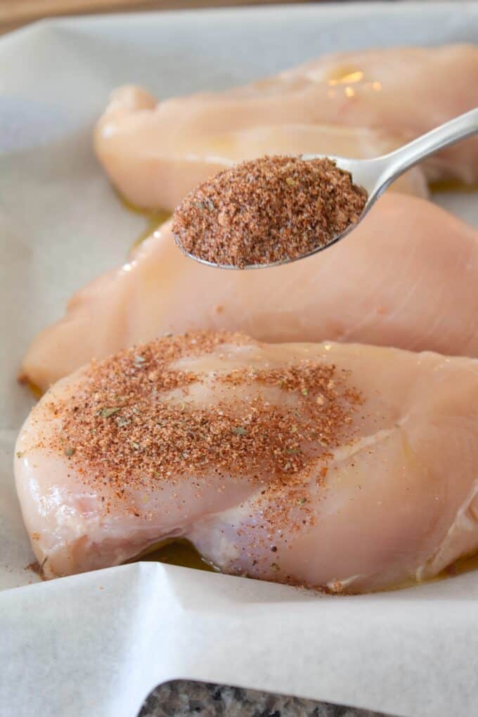 sprinkling blackening seasoning on chicken