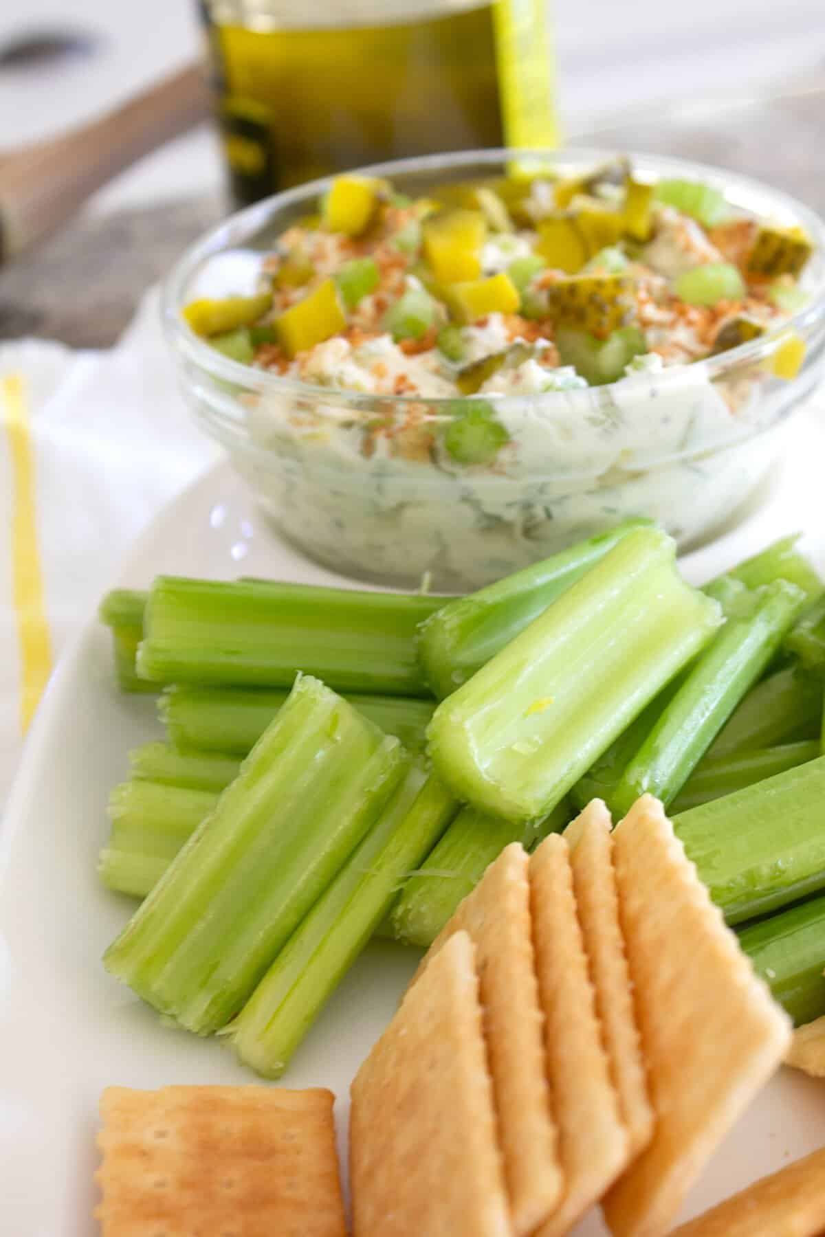 platter of pickle dip with celery dippers and crackers