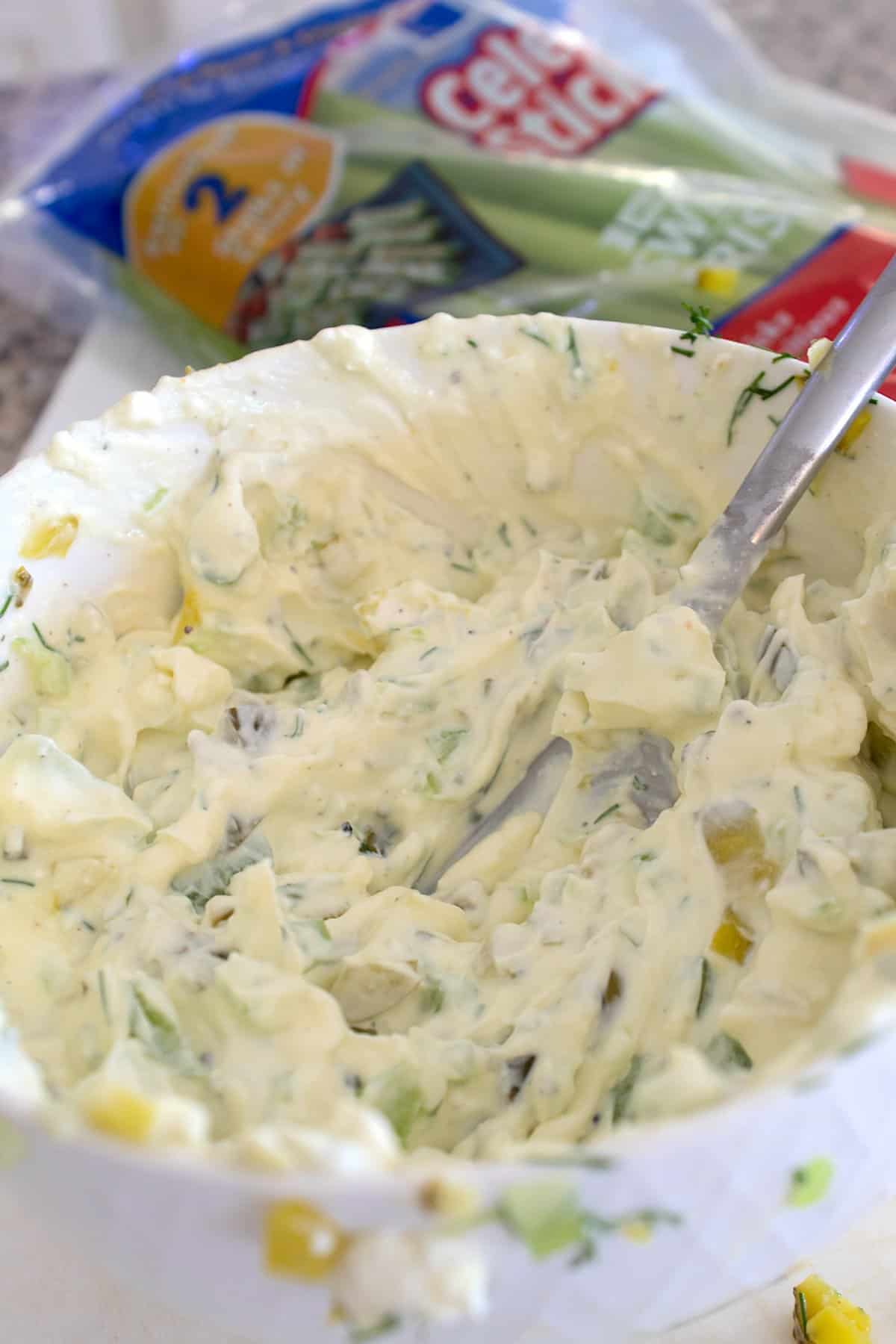 mixing pickle dip in a bowl