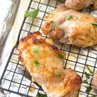 angled photo of chicken thighs baked on a sheet pan