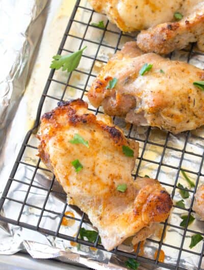 angled photo of chicken thighs baked on a sheet pan