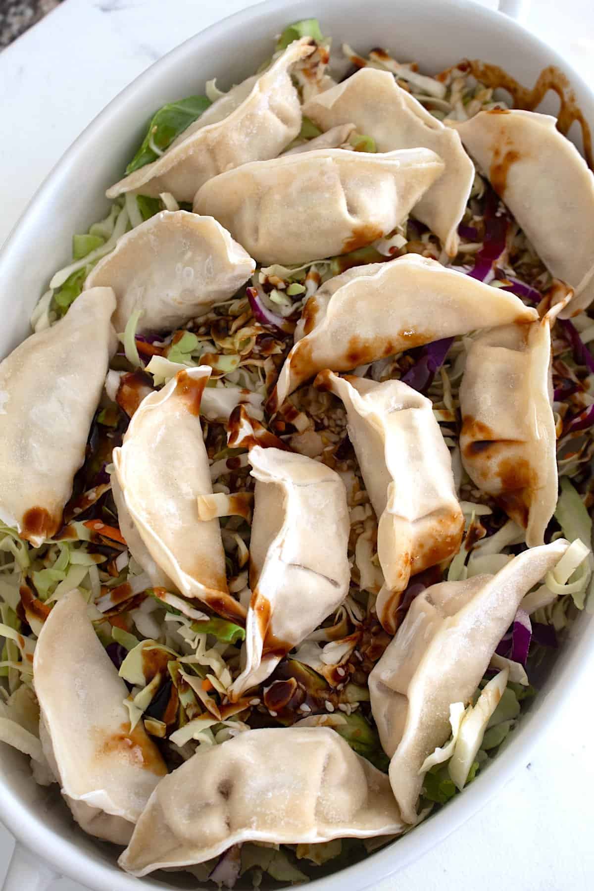 overhead shot of frozen wontons with cabbage slaw baked