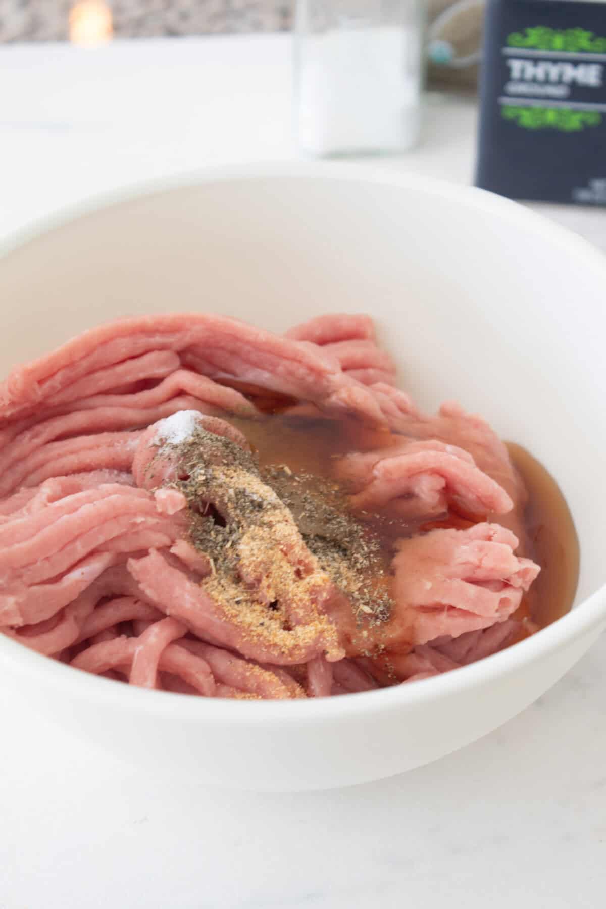raw breakfast sausage ingredients in a light green bowl