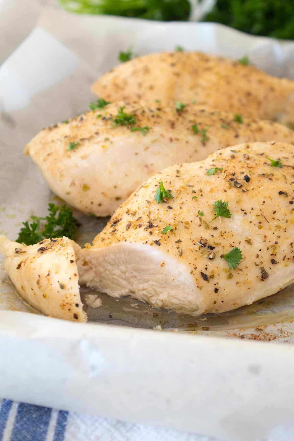 chicken breasts on a sheet pan with parchment
