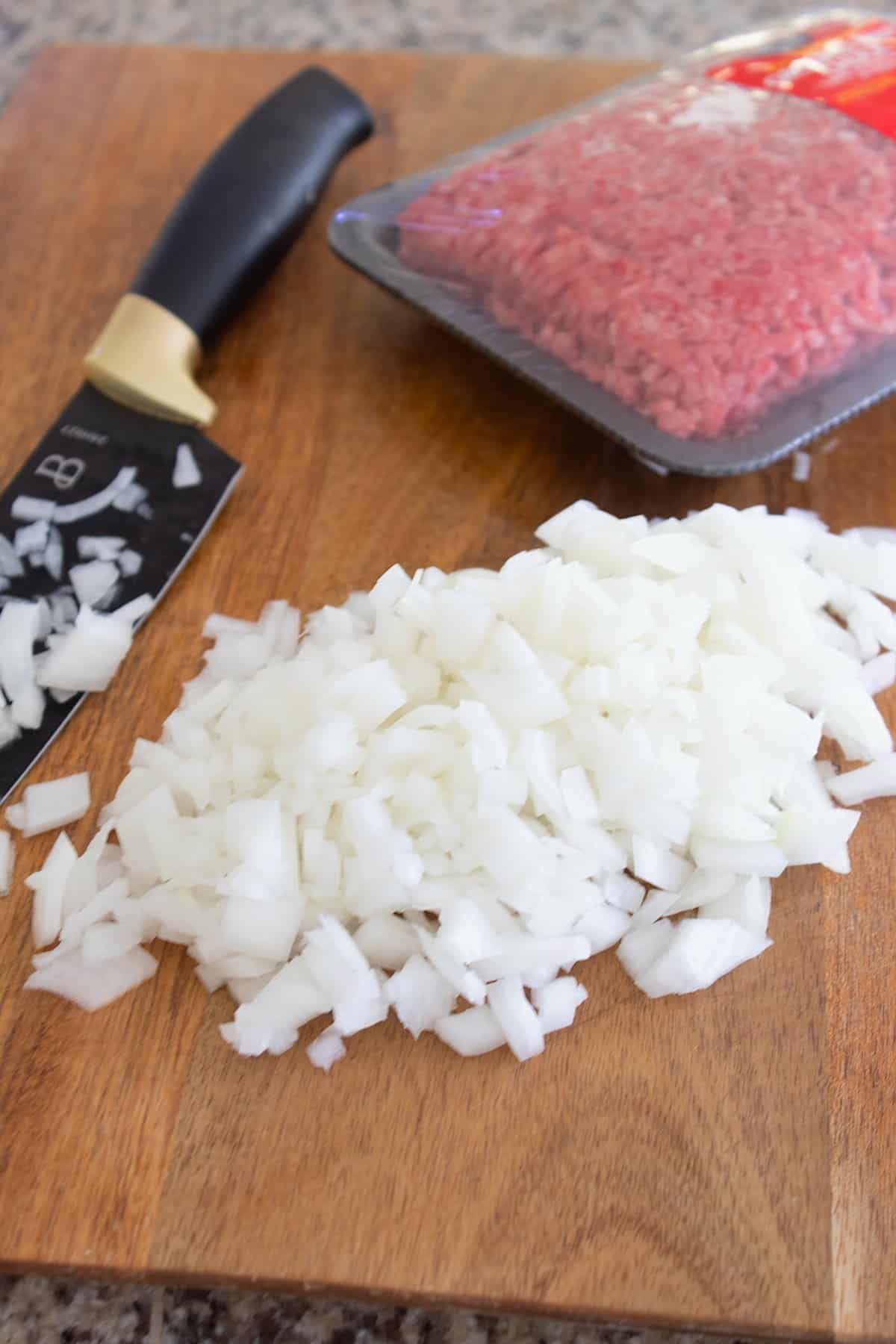 ground beef and onion on a cutting board