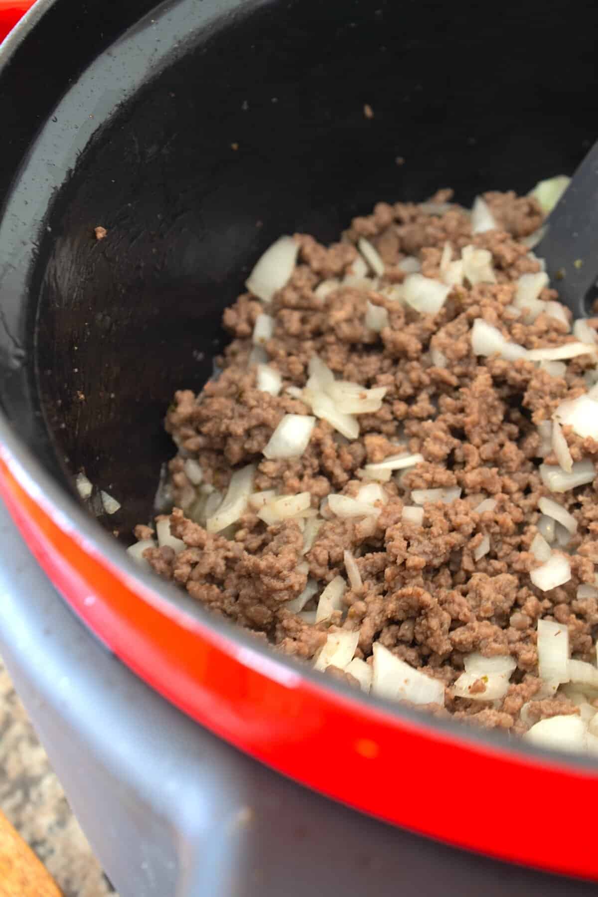 sautéed ground beef and onion in a red pot