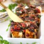 marinated cheese in a rectangular dish with marinade on it