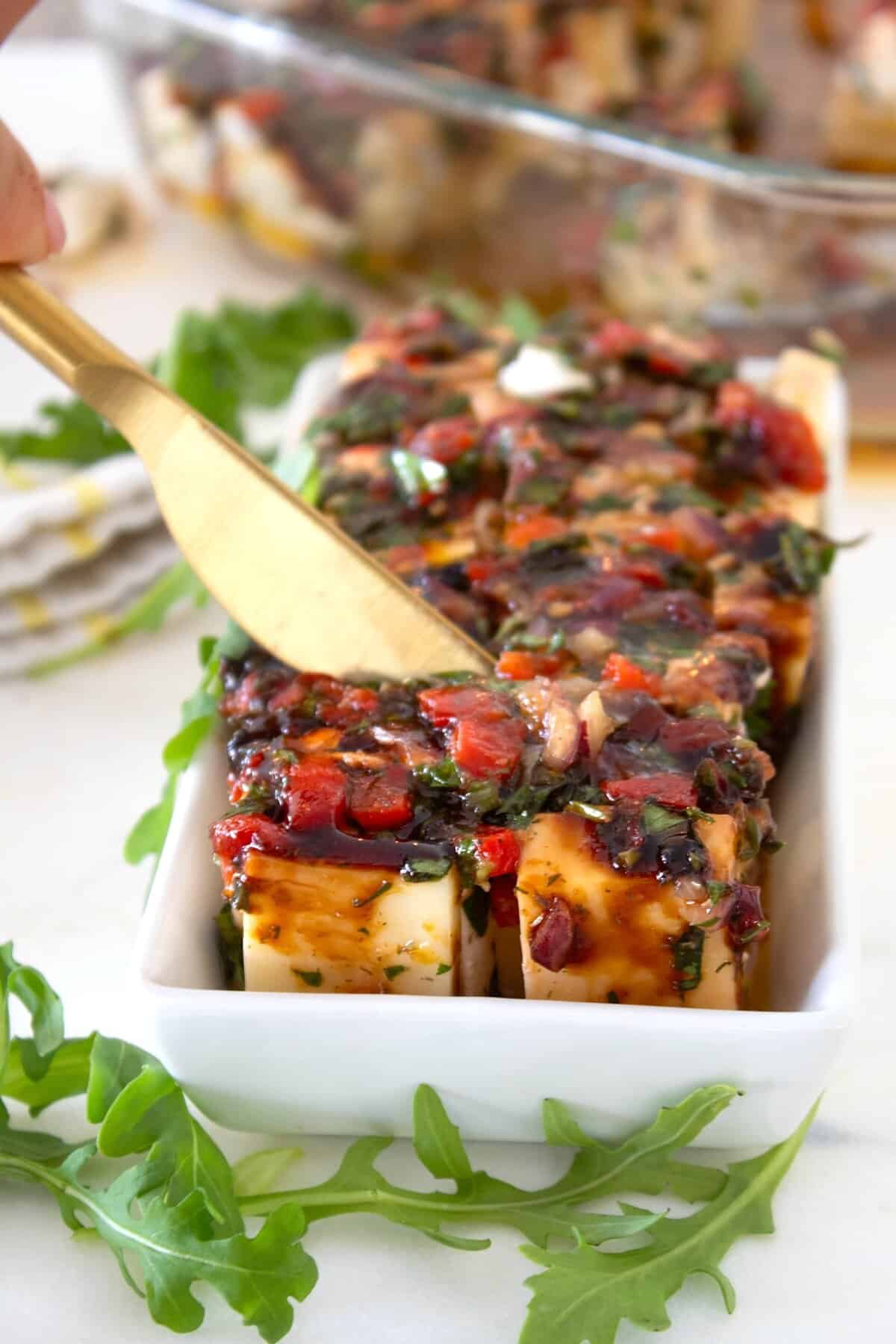 marinated cheese in a rectangular dish with marinade on it