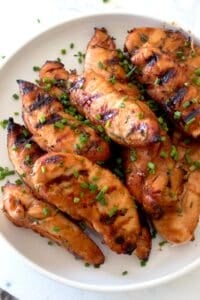 overhead shot of grilled chicken tenders on a white plate