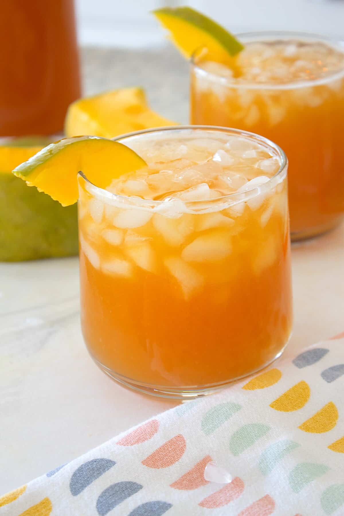 mango iced tea in a glass on a tea towel