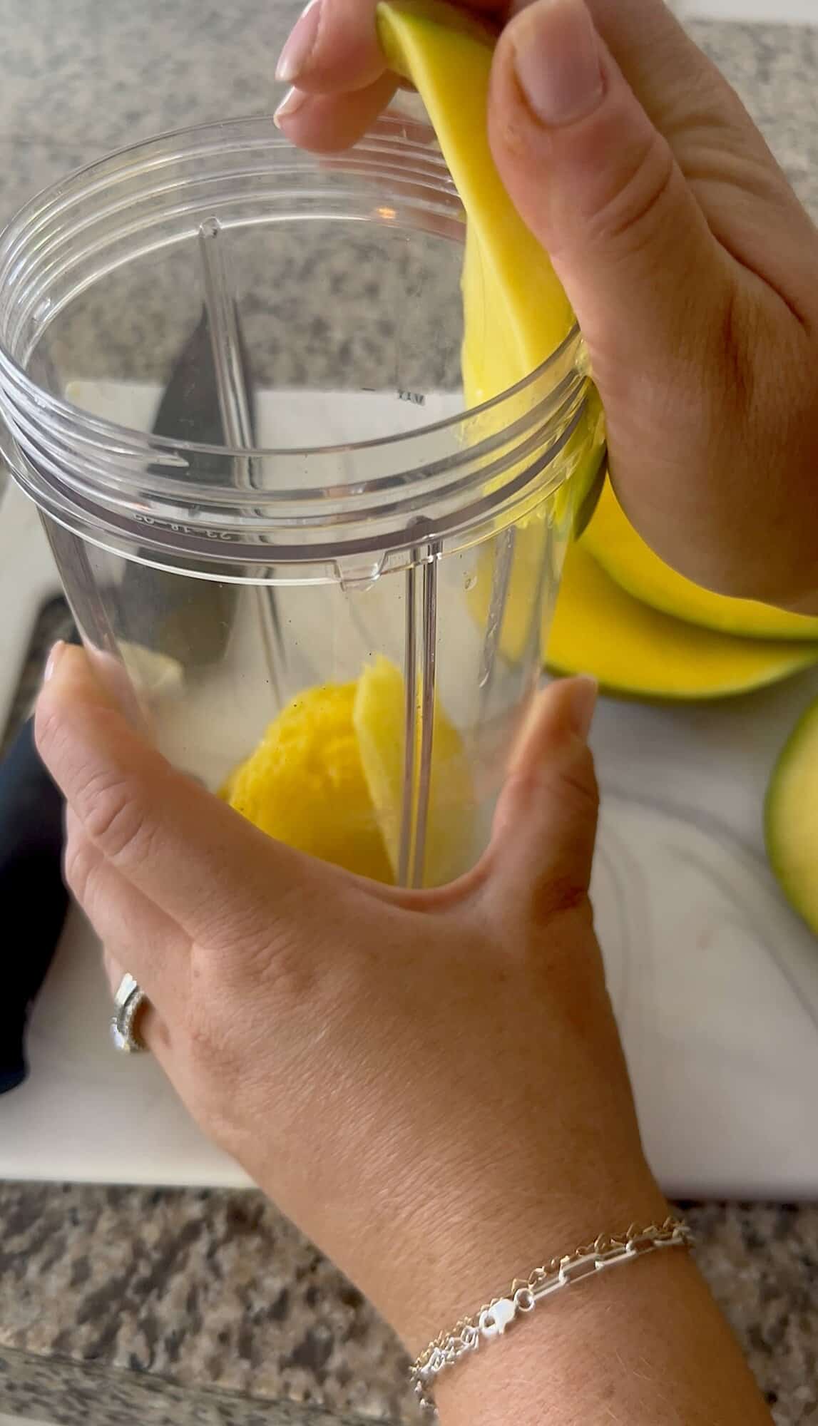 peeling mango skin against blender cup