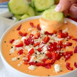 dipping a cucumber in red pepper dip