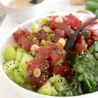 overhead view of poke bowl with garnishes in a white bowl